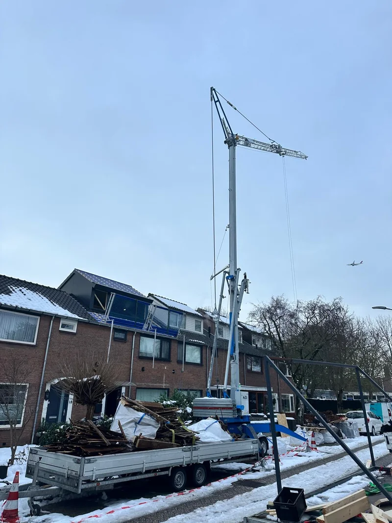 Hijskraan bij de montage van een dakverhoging op een rijwoning