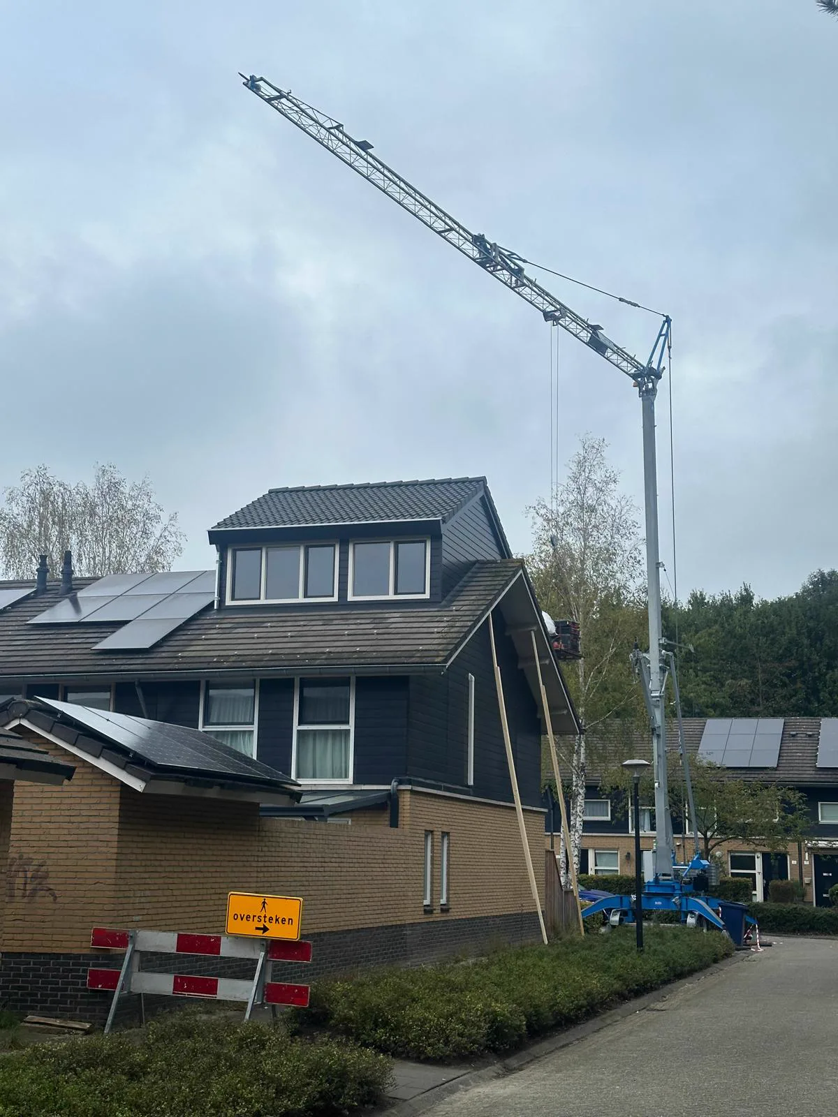 Woning in Almere met de geplaatste nokverhoging en de hijskraan nog naast de woning